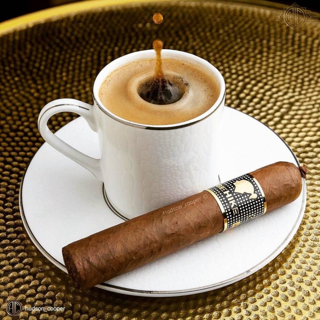 Cup of coffee next to a coffee flavored cigar